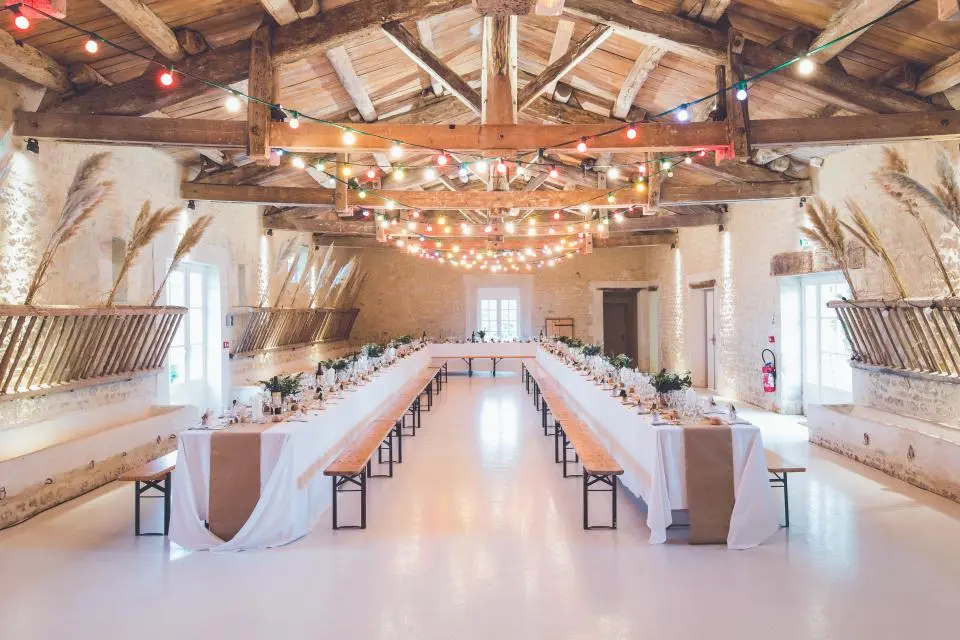 Event venue with long tables set beneath string lights