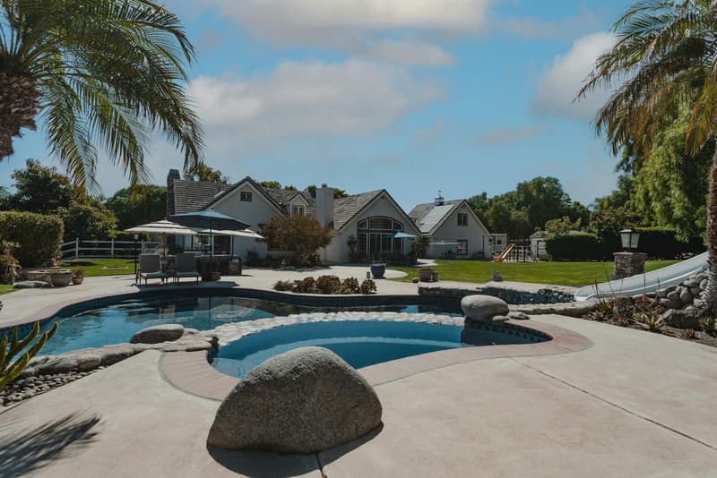 Two-story home with pool and palms