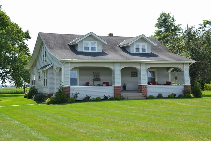 Shingle-style home with wraparound porch