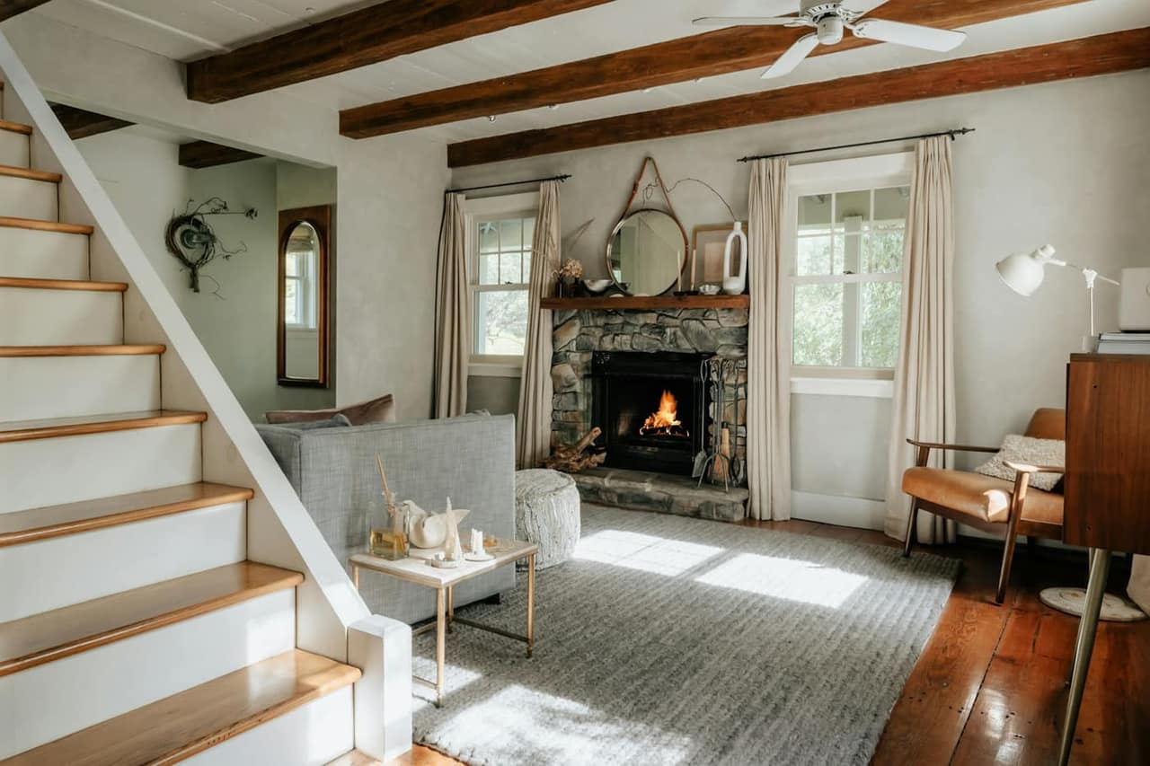 Living room with a stone fireplace and staircase